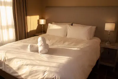 a white bed with two stuffed animals on it at Casa de la Presa 1 in Polokwane