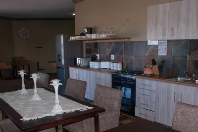 a kitchen with a table and a stove top oven at Casa de la Presa 1 in Polokwane