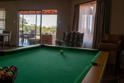 a pool table in a living room with a pool ball at Casa de la Presa 1 in Polokwane