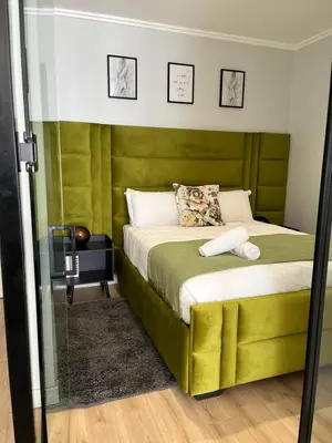 a bedroom with a bed with a green headboard at Ellipse waterfall midrand in Midrand