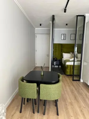 a black table and chairs in a room with a bed at Ellipse waterfall midrand in Midrand