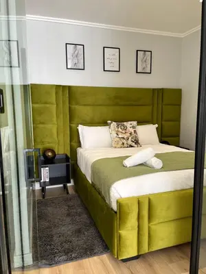 a bedroom with a bed with a green headboard at Ellipse waterfall midrand in Midrand