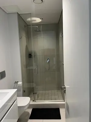 a bathroom with a shower with a glass door at Ellipse waterfall midrand in Midrand