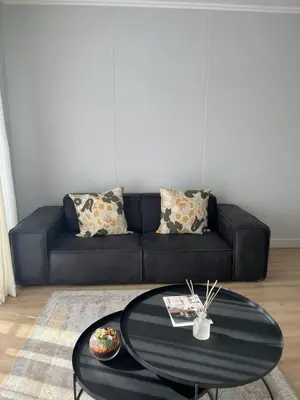 a black couch in a living room with a table at Ellipse waterfall midrand in Midrand