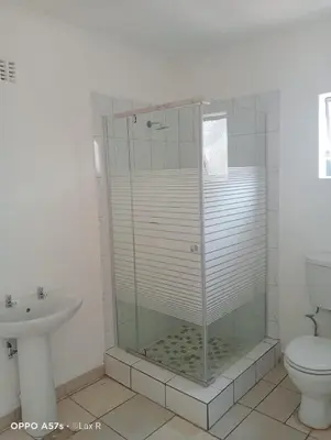 a bathroom with a shower with a toilet and a sink at 7 Geelhout Ave in Nelspruit