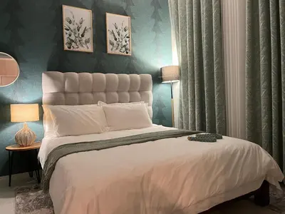 a bedroom with a large white bed with blue walls at Cozy retreat in Carlswald 264 in Midrand