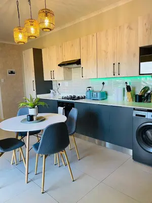 a kitchen with a table and chairs and a stove at Cozy retreat in Carlswald 264 in Midrand