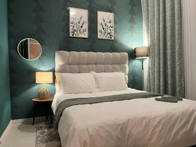 a bedroom with a large bed with green walls at Cozy retreat in Carlswald 264 in Midrand