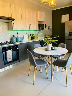 a kitchen with a table and chairs in a kitchen at Cozy retreat in Carlswald 264 in Midrand