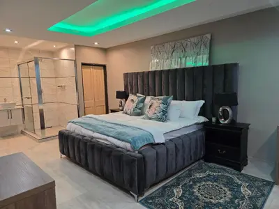 a large bedroom with a large bed and a shower at Nyamankulu Guest Lodge in Thulamahashi