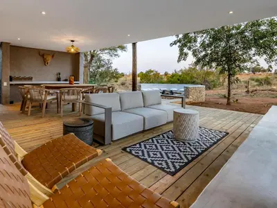 a living room with a couch on a wooden deck at Nare Bush Lodge in Marloth Park