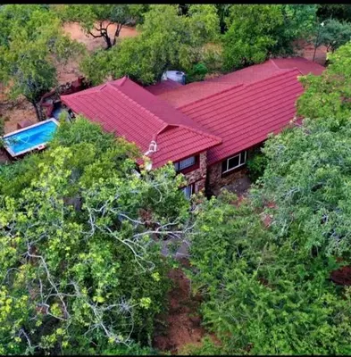 an overhead view of a house with a red roof at Luxury GuesthouseCo FlintstoneHouse in Marloth Park
