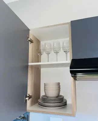 a cupboard with plates and wine glasses in it at Dubai 8 in Midrand