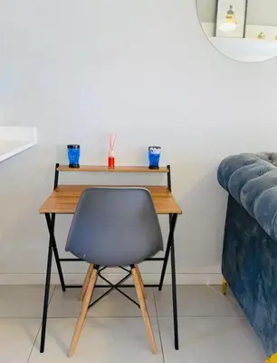 a wooden table with a chair next to a couch at Dubai 8 in Midrand