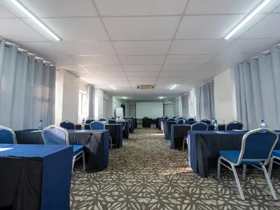 a conference room with blue tables and chairs at ANEW Hotel & Convention Centre OR Tambo Johannesburg in Benoni