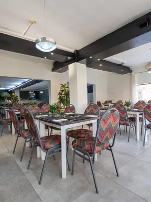 a group of tables and chairs in a restaurant at ANEW Hotel & Convention Centre OR Tambo Johannesburg in Benoni