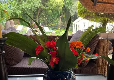 a blue vase filled with flowers on a table at The Flamingo Suite at Frederick's Place in Pretoria