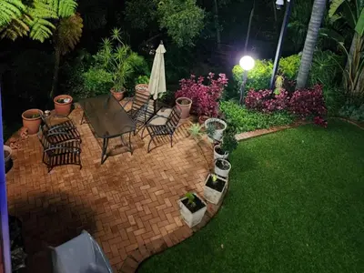 a backyard at night with a table and chairs at Loerie's Nest in Pretoria