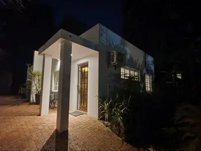 a house at night with a lit up door at Loerie's Nest in Pretoria