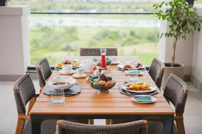 a wooden table with plates of food on it at Steyn City Hotel by Saxon in Midrand