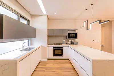 a kitchen with white cabinets and a sink at Steyn City Hotel by Saxon in Midrand