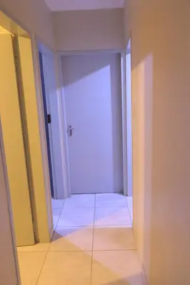 an empty hallway with a white door in a room at Zone 4 Motel in Polokwane