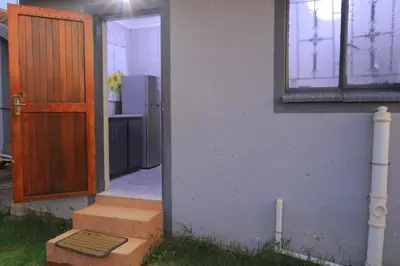 a door leading to a kitchen with a refrigerator at Zone 4 Motel in Polokwane