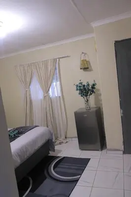 a bedroom with a bed and a window at Zone 4 Motel in Polokwane