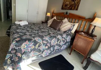 a bedroom with a bed with a colorful comforter at The Rhino Room at Frederick's Place in Pretoria
