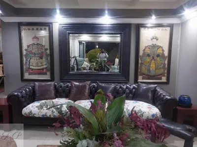 a leather couch in a living room with pictures on the wall at The Rhino Room at Frederick's Place in Pretoria
