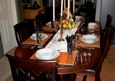 a wooden table with plates and utensils on it at The Rhino Room at Frederick's Place in Pretoria