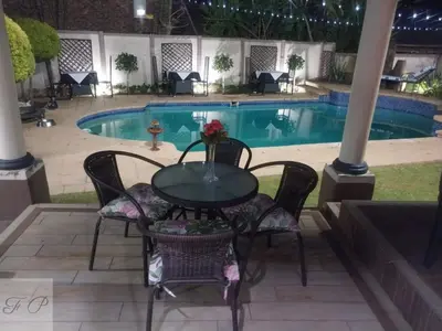 a table and chairs in front of a pool at The Rhino Room at Frederick's Place in Pretoria