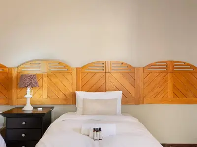 a bedroom with a large bed with wooden headboards at Kniff un Gaffel Guest House in Pretoria