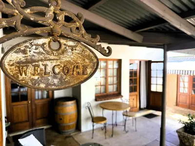 a sign for a winery with a table and chairs at Kniff un Gaffel Guest House in Pretoria