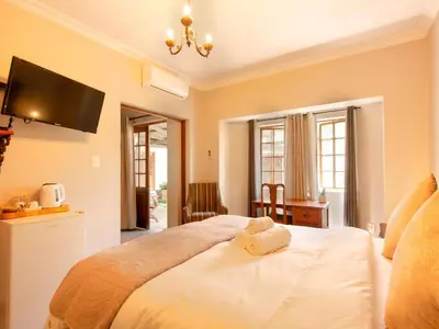 a bedroom with a bed with a towel on it at Kniff un Gaffel Guest House in Pretoria