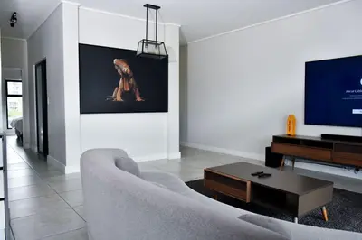 a living room with a couch and a flat screen tv at Feelathome in Midrand