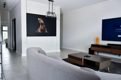 a living room with a couch and a flat screen tv at Feelathome in Midrand