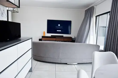 a living room with a couch and a flat screen tv at Feelathome in Midrand
