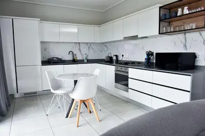 a kitchen with white cabinets and a table and chairs at Feelathome in Midrand