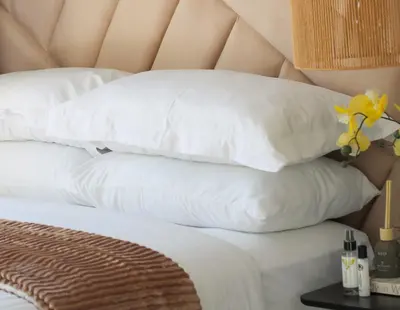 a bed with white pillows and yellow flowers on it at Lizzy's Residence in Midrand