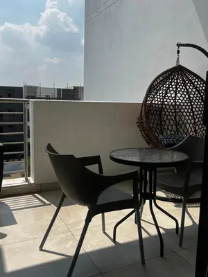 a table and chairs on a balcony with a swing at Lizzy's Residence in Midrand