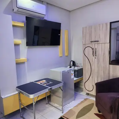 a small kitchen with a table and a refrigerator at Duplessis Lodge in Kempton Park