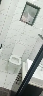 a white bathroom with a toilet and a window at Duplessis Lodge in Kempton Park