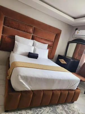 a bedroom with a large bed with a wooden headboard at Duplessis Lodge in Kempton Park