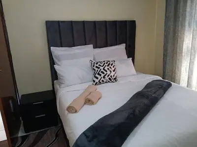 a bed with two towels on top of it at Vuyani Guest Lodge in Malamulele