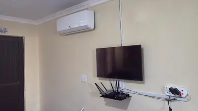 a flat screen tv hanging on a wall at Vuyani Guest Lodge in Malamulele