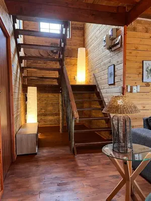 a room with a staircase with a couch and a table at Croc's Nest Bush Lodge in Marloth Park
