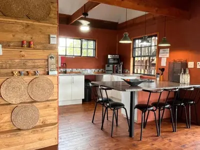 a kitchen with a table and some chairs in it at Croc's Nest Bush Lodge in Marloth Park