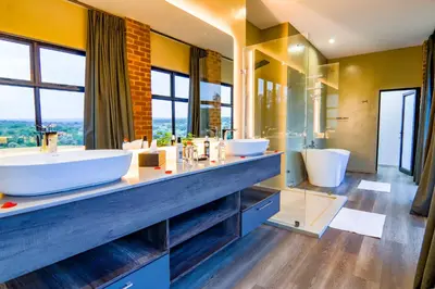 a bathroom with two sinks and a large mirror at Cliffhanger Lodge in Mabula