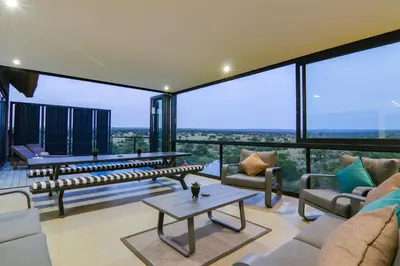 a living room with couches and a table at Cliffhanger Lodge in Mabula